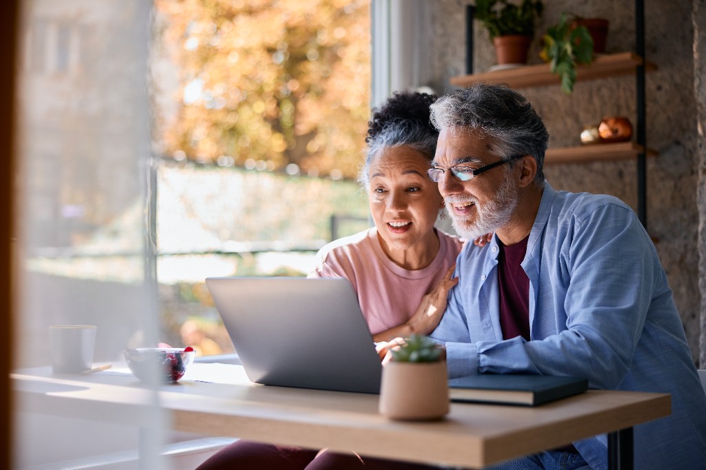 Retired couple reviewing their financial plan on a laptop at home